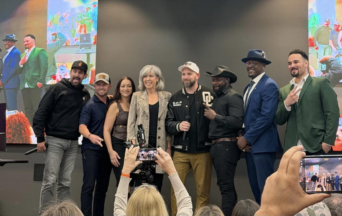 Michele Bastone on stage with a group at an industry event.